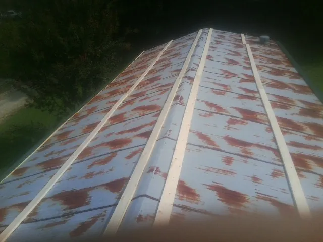 Rusted metal roof panels with new wood purlins before replacement — Storm Damage Roof Repair in Island by Roofing Brothers