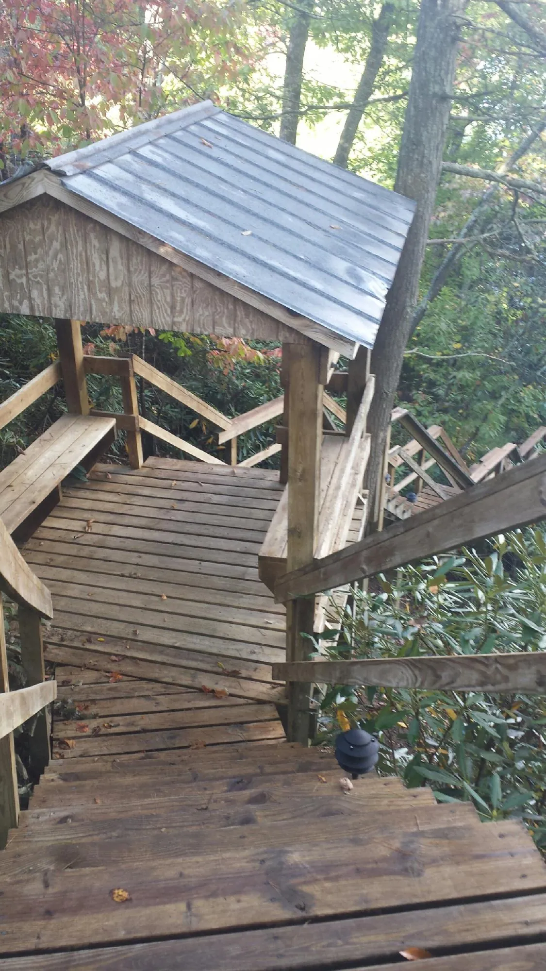 Metal roofed shelter over wooden steps on a wooded walkway — Skylight Repair & Installation work by our crew in Island