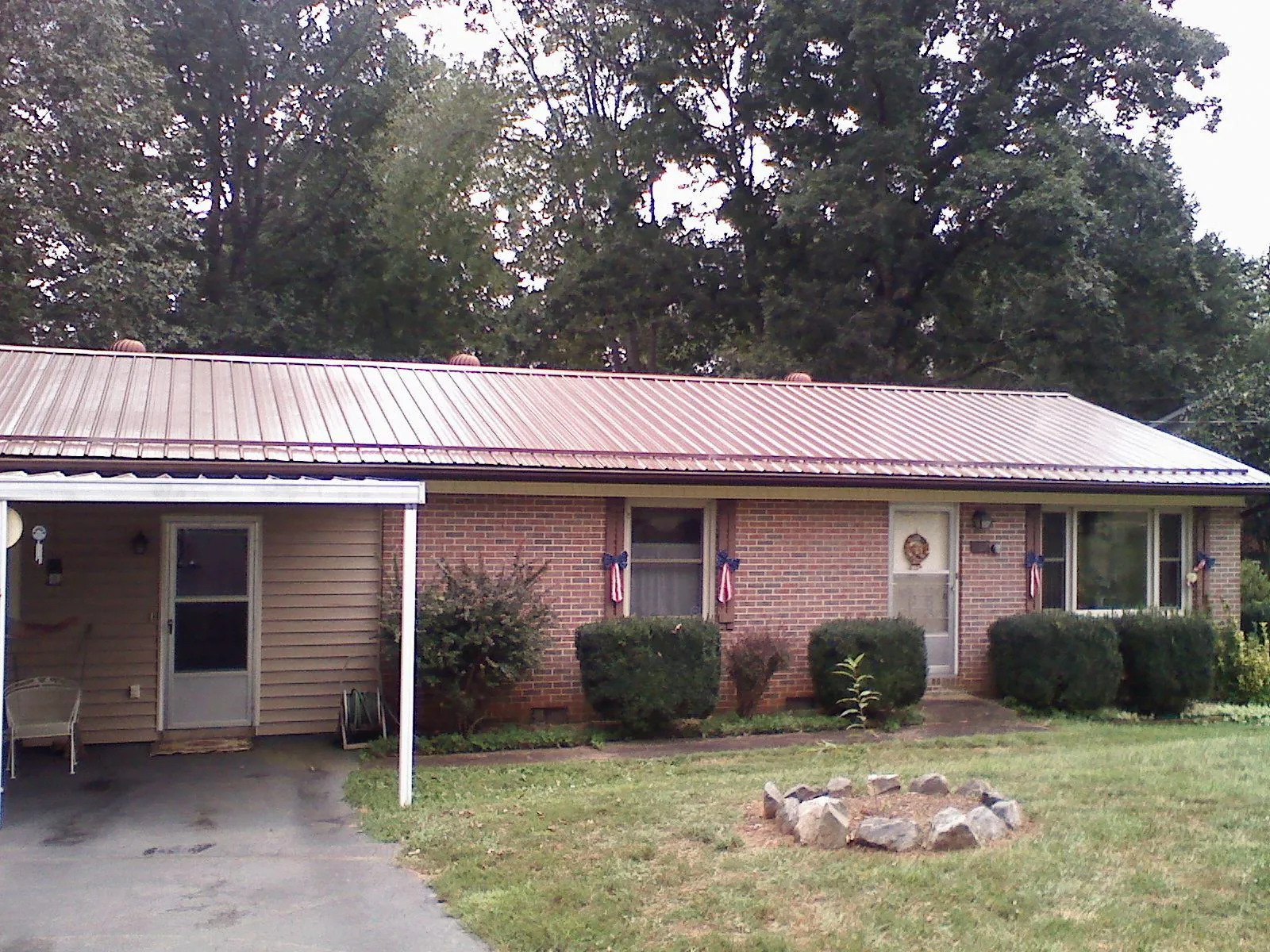 Bronze metal roof and carport on a brick ranch home — Roof Repair work by our crew in Island